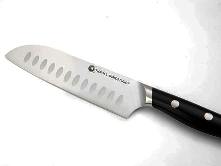 A close-up of a Royal Prestige chef's knife with a shiny stainless steel blade and black handle with three rivets, featuring oval cutouts along the blade's edge against a white background.